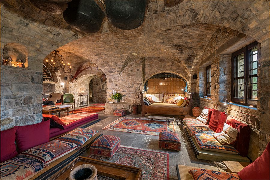 Cosy interior of a brick-lined room filled with patterned and cushioned sofas at Eremito Hotelito del Alma.